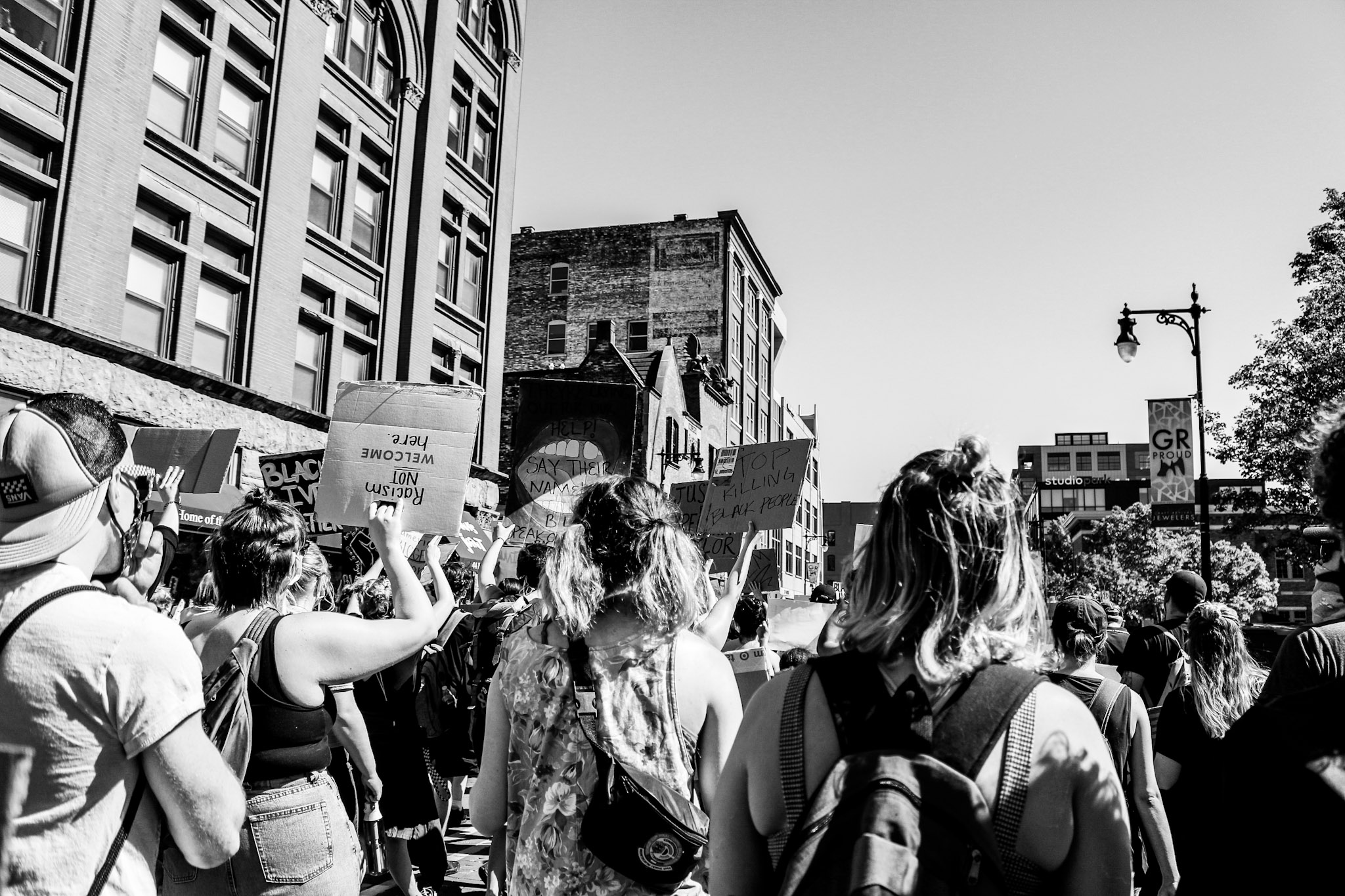 black and white photo of protesters with cardboard signs walking down the street