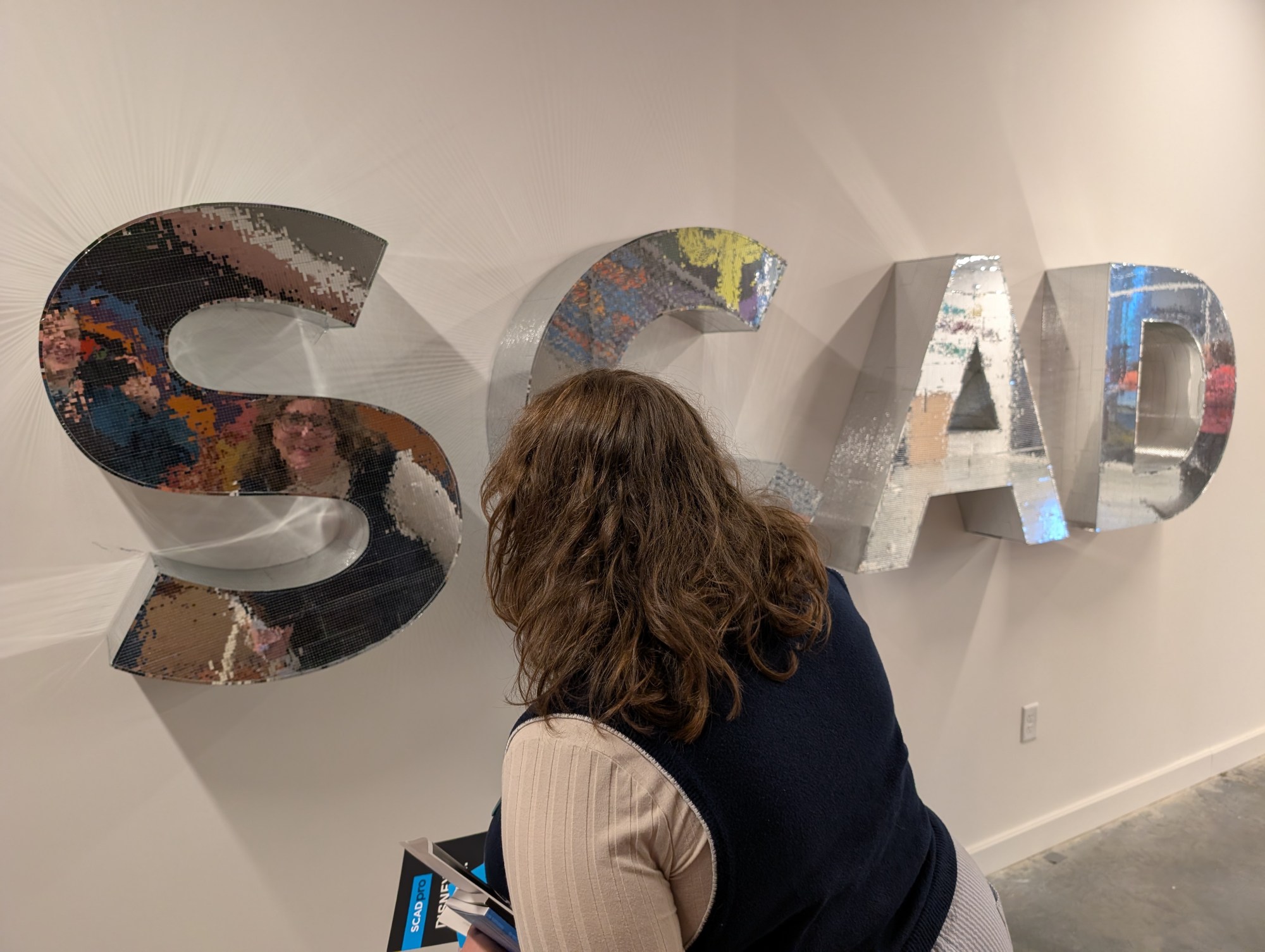 Kate looks at reflective letters spelling SCAD.